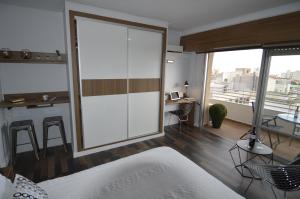 a bedroom with a large sliding glass door with a desk at Lukentum Suites in Alicante