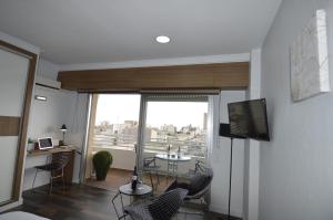 a living room with a television and a table and chairs at Lukentum Suites in Alicante