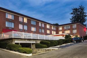 un gran edificio de ladrillo con un coche aparcado delante de él en Ramada by Wyndham Ligonier en Ligonier