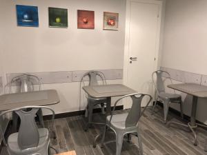 a room with tables and chairs and paintings on the wall at Caio Duilio B&B in Messina