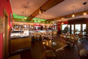 a restaurant with tables and chairs and a bar at Casteluce Hotel Funivie in Pinzolo