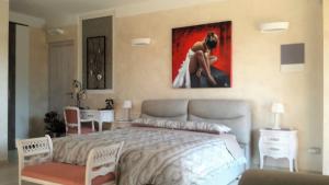 ein Schlafzimmer mit einem Bett und einem Gemälde an der Wand in der Unterkunft Dimora La Risorgiva in Ca' di David + 65 Fotos