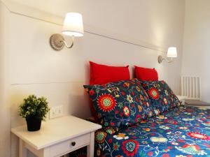 ボローニャにあるSleep & Flyのベッドルーム1室(赤い枕とテーブル付きのベッド1台付)