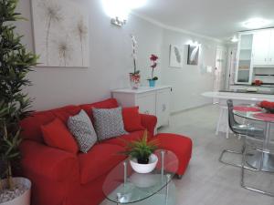a living room with a red couch and a table at Piso Puerto Naos a 1 Minuto de la Playa in Puerto Naos