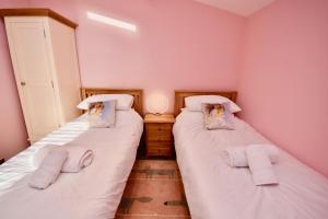 ウートン・ブリッジにあるCreek Viewのピンクの壁の客室で、ツインベッド2台が備わります。
