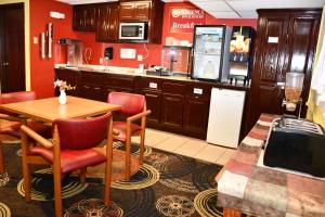 cocina con mesa, sillas y barra en Regency Inn & Suites Faribault, en Faribault