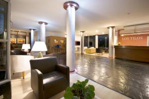 a lobby of a hotel with a chair and tables at Los Tilos Hotel y Spa by CPH in Villa Carlos Paz