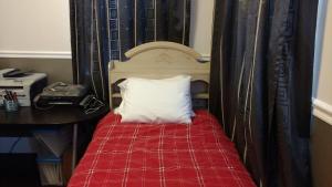 a bed with a red blanket and a white pillow at Homestay in Westwood 97909 in Cincinnati