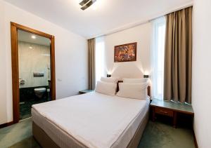 Hotel Duke Romana tesisinde bir odada yatak veya yataklar
