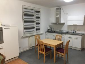 una cocina con mesa de madera y sillas. en Ferienwohnung Amanda en Stützerbach