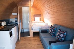 a living room with a couch and a bed in a room at Skeabost View Pods Skye in Portree