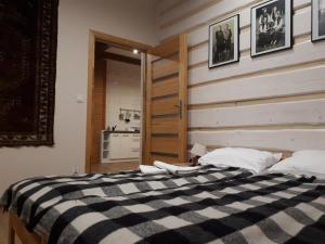ein Schlafzimmer mit einem Bett mit einer schwarzen und weißen Decke in der Unterkunft Apartamenty "Maryna House" Zakopane in Zakopane