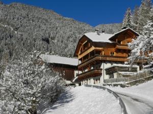 un gran edificio en la nieve junto a una montaña en Gedrarzerhof, en Luson