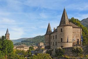 un antico castello con due torri su una collina di Logis Hotel Restaurant des Gorges du Tarn a Florac