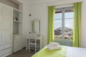 a bedroom with a bed and a desk and a window at Agnanti in Kastron