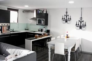 cocina y sala de estar con mesa blanca y sillas en My Hostel, en Guimarães
