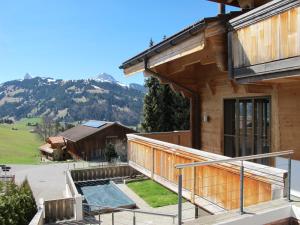 uma vista para a frente de uma casa de madeira com uma banheira de hidromassagem em Cala Sol em Gstaad
