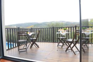 einen Balkon mit Stühlen und einem Tisch mit Essen darauf in der Unterkunft Casa da Fraga in Ferreira