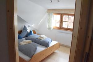 ニーダートハイにあるHaus Christianのベッドルーム1室(青い枕と窓付きのベッド2台付)