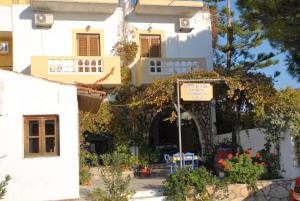 a white house with a sign in front of it at Rent Rooms Katerina in Kalamaki