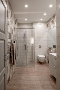 a bathroom with a shower and a toilet and a sink at Comfort Stay - Klaipeda in Klaipėda +41 photos