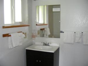 a white sink sitting under a mirror in a bathroom at Ocean Avenue Inn in Westport