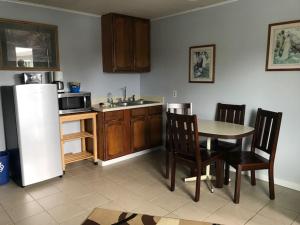 a kitchen with a table and chairs and a refrigerator at Ocean Avenue Inn in Westport