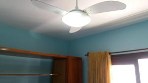 a ceiling fan in a room with blue walls at Sobrado Hibisco in Capão da Canoa