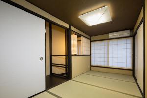 京都松原堺町纺织度假屋的天花板上有一扇门和一盏灯的房间
