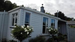uma casa branca com flores brancas à frente em Villa on Milton em Nelson