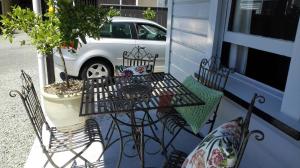 un patio con mesa y sillas en un porche en Villa on Milton en Nelson