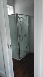 a glass shower with a glass door in a room at Villa on Milton in Nelson