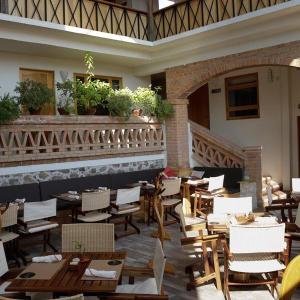 un ristorante con tavoli e sedie in legno in un edificio di Casa Tsaya Hotel Boutique a Bernal