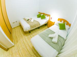 1 dormitorio con 2 camas y almohadas verdes en Homely Apartments Blasco Ibañez, en Torrevieja