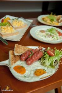 a table with plates of eggs and toast with sausage at The Pilgrim Hotel in Hanoi
