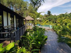 a house with a walkway next to a garden at Koyao Bay Pavilions - SHA Extra Plus in Ko Yao Noi