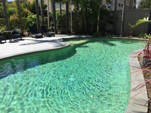 a swimming pool with blue water in a yard at Araluen Motor Lodge in Batemans Bay