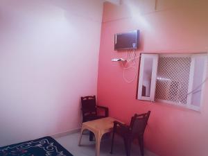 um quarto com uma mesa e cadeiras e uma televisão em Hotel Blue Heaven em Fatehpur Sīkri