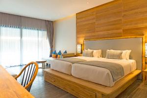 a bedroom with a large bed and a table at AKIRA Lipe Resort in Ko Lipe