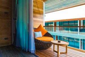 a balcony with a chair and a table on a building at AKIRA Lipe Resort in Ko Lipe