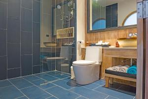a bathroom with a toilet and a glass shower at AKIRA Lipe Resort in Ko Lipe
