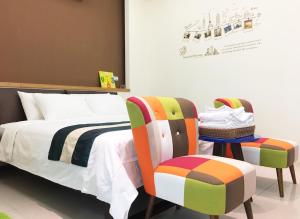 a bedroom with a bed and two chairs at Ashore 196 B&B in Dongshan