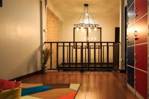 a hallway with a staircase with a chandelier in a room at T2 Hostel Thappraya 12 in Pattaya South
