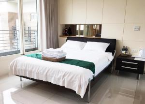 a bedroom with a bed with white sheets and a window at Ashore 196 B&B in Dongshan +20 photos