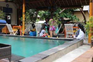 
people sitting in a swimming pool at The Lakshmi Villas in Gili Trawangan
