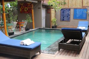 uma piscina com duas cadeiras e uma mesa em The Lakshmi Villas by The Beach House em Gili Trawangan