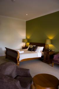 um quarto com uma cama grande e uma parede verde em The Bridgetown Hotel em Bridgetown
