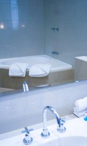 a bathroom with two sinks and a tub in a mirror at The Bridgetown Hotel in Bridgetown