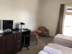 a hotel room with a desk with a computer and a bed at The Bridgetown Hotel in Bridgetown