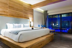 a bedroom with a large bed and a large window at AKIRA Lipe Resort in Ko Lipe
